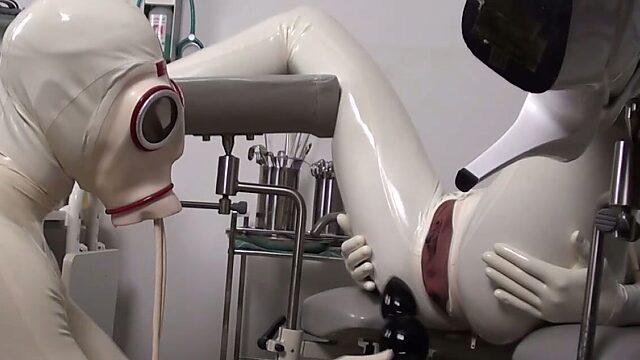 Latex doctor and latex patient on the gyno chair