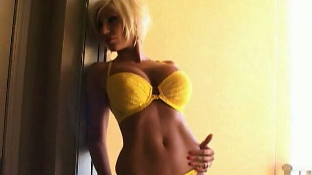 Short haired blond haired bimbo poses in her yellow bikini in doorjamb