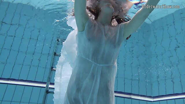Красивая брюнетка Андрэжка снимает с себя белое платье под водой и плавает голая