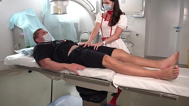 Horny brunette nurse in red stockings takes care of a well-endowed patient