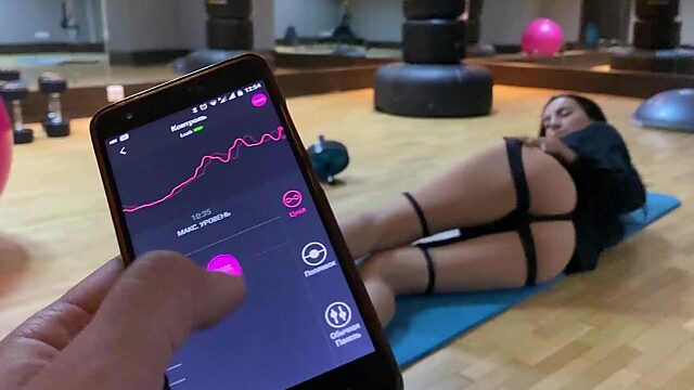 Athletic brunette gets her muff stimulated by remote vibrator in gym solo